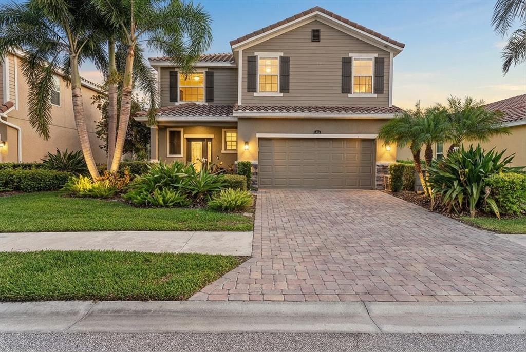 5439 Cartagena Drive Sarasota, FL 34233 - Photo 1 of 40 a front view of a house with a yard and garage