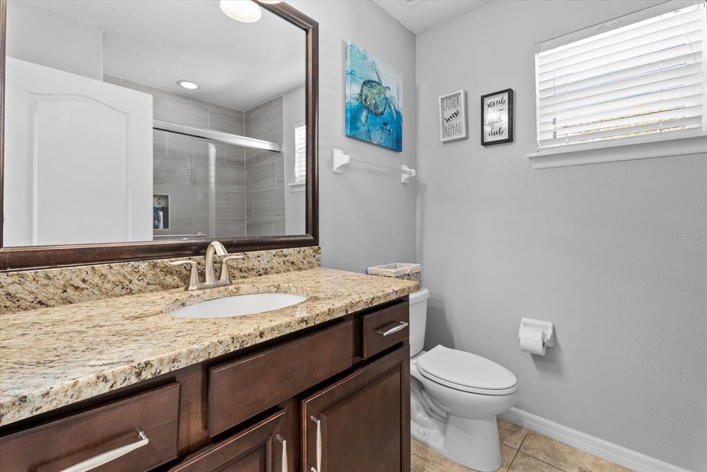5439 Cartagena Drive Sarasota, FL 34233 - Photo 25 of 40 a bathroom with a granite countertop toilet sink and mirror
