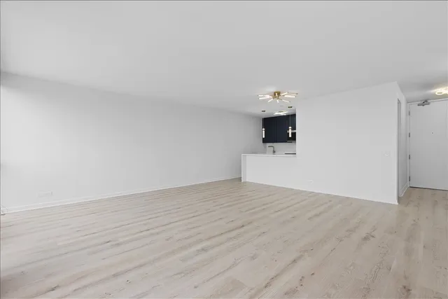a view of empty room with wooden floor and fireplace