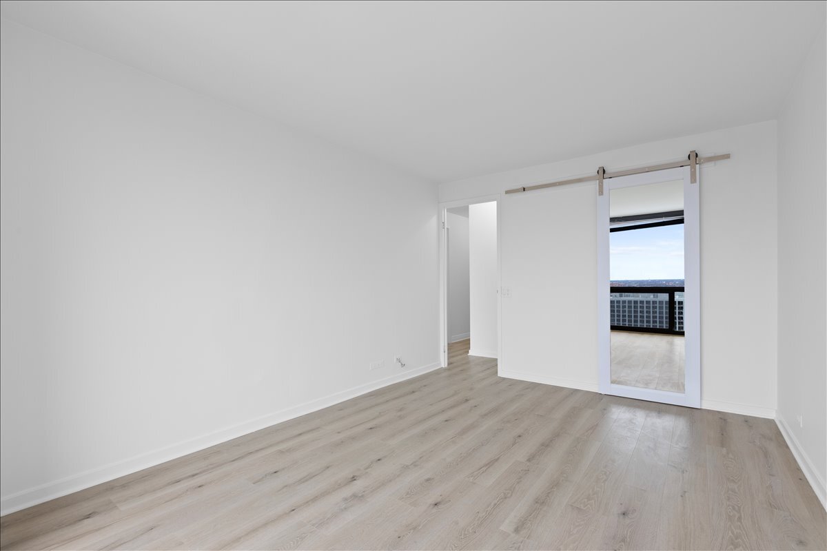 4343 North Clarendon Avenue, Unit 2507 Chicago, IL 60613 - Photo 16 of 23 a view of an empty room with wooden floor and a window