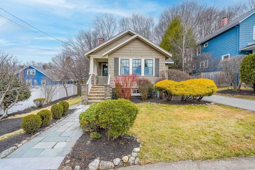 a front view of house with yard and trees in the background