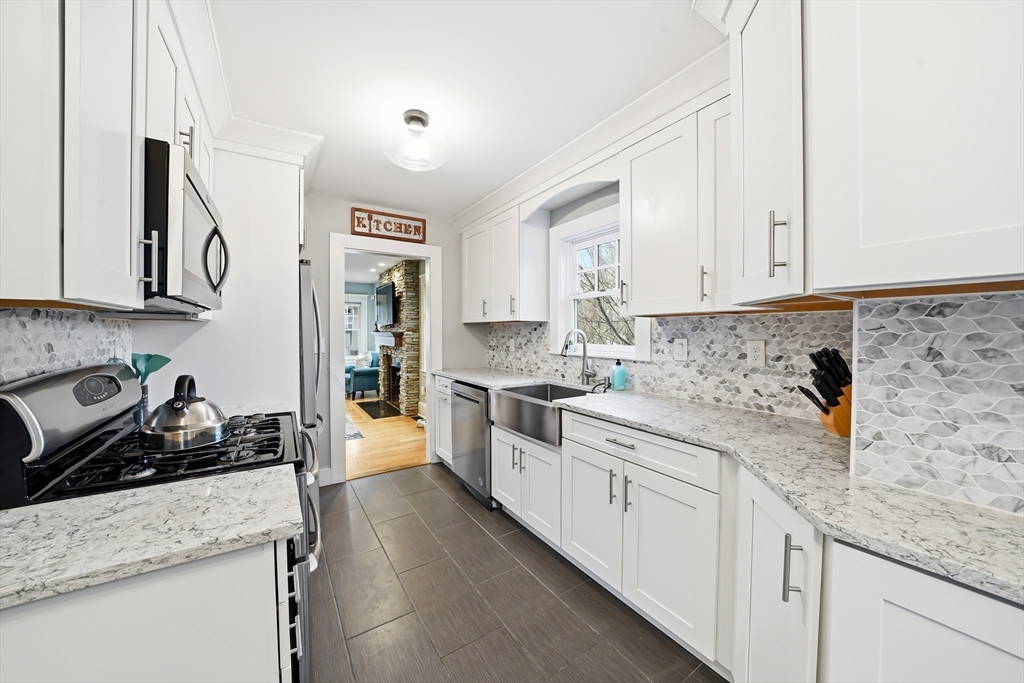 4 Wescott Road Stoneham, MA 02180 - Photo 17 of 42 a kitchen with stainless steel appliances granite countertop a sink stove and cabinets