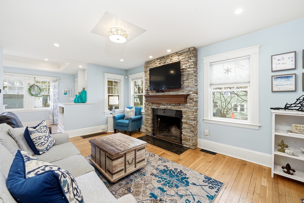 4 Wescott Road Stoneham, MA 02180 - Photo 2 of 42 a living room with furniture a flat screen tv and a fireplace