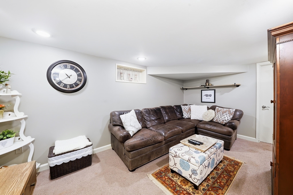 4 Wescott Road Stoneham, MA 02180 - Photo 27 of 42 a living room with furniture a clock and a window