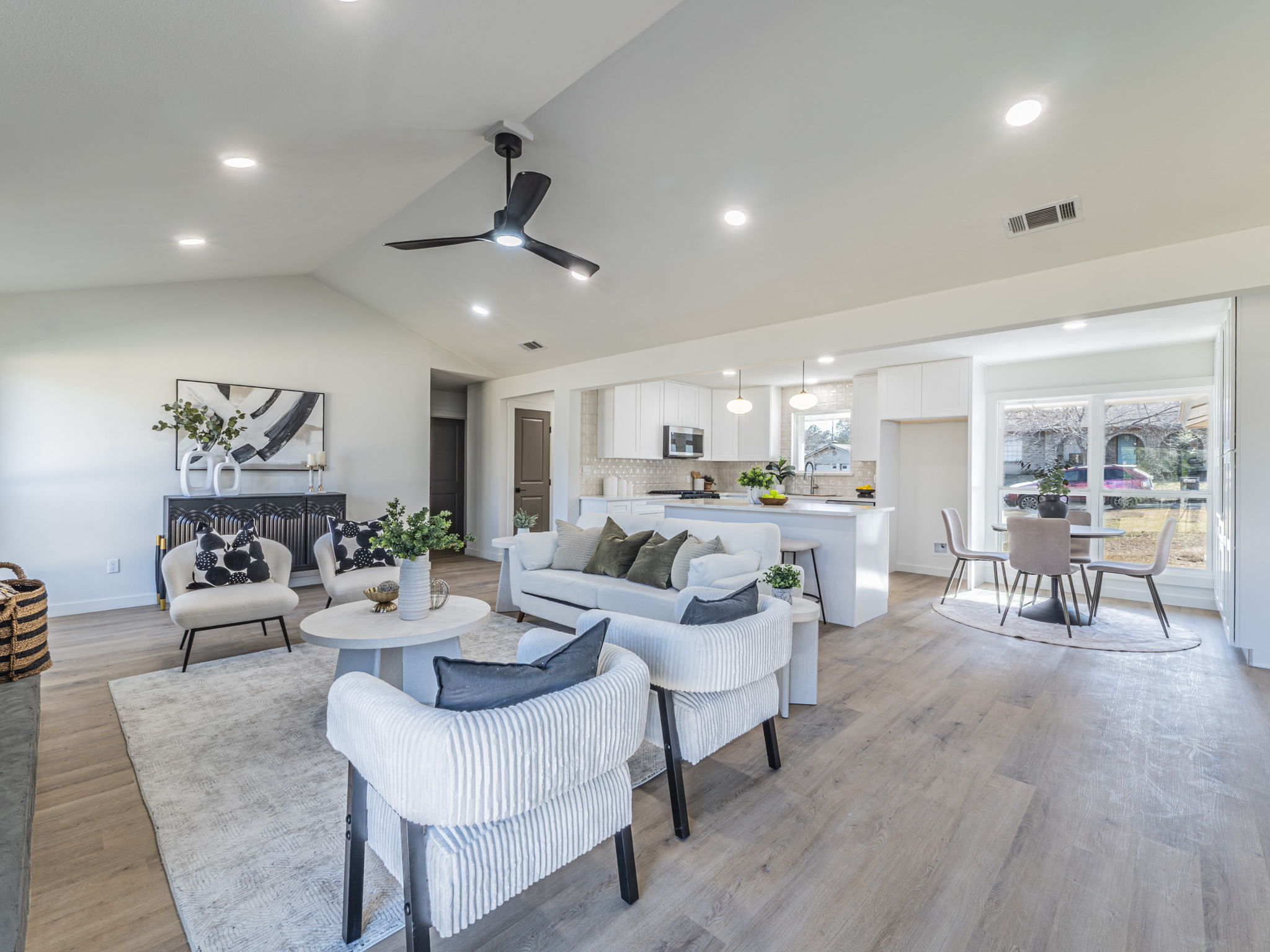 Living room with lofted ceiling, light wood finished floors, a ceiling fan, and recessed lighting