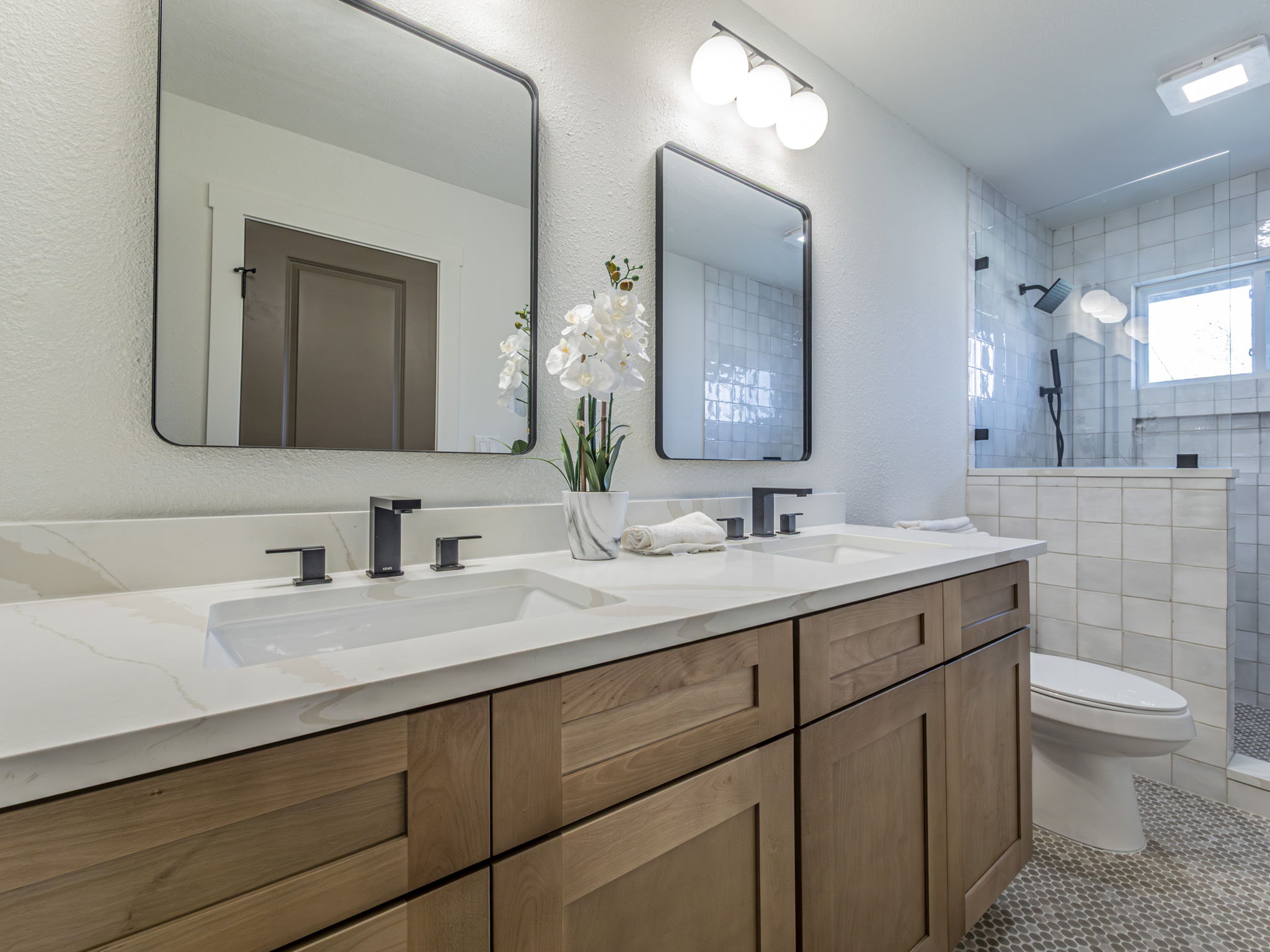 906 Fall Creek Drive Austin, TX 78753 - Photo 10 of 25 Full bath with walk in shower, double vanity, light tile patterned floors, and a textured wall