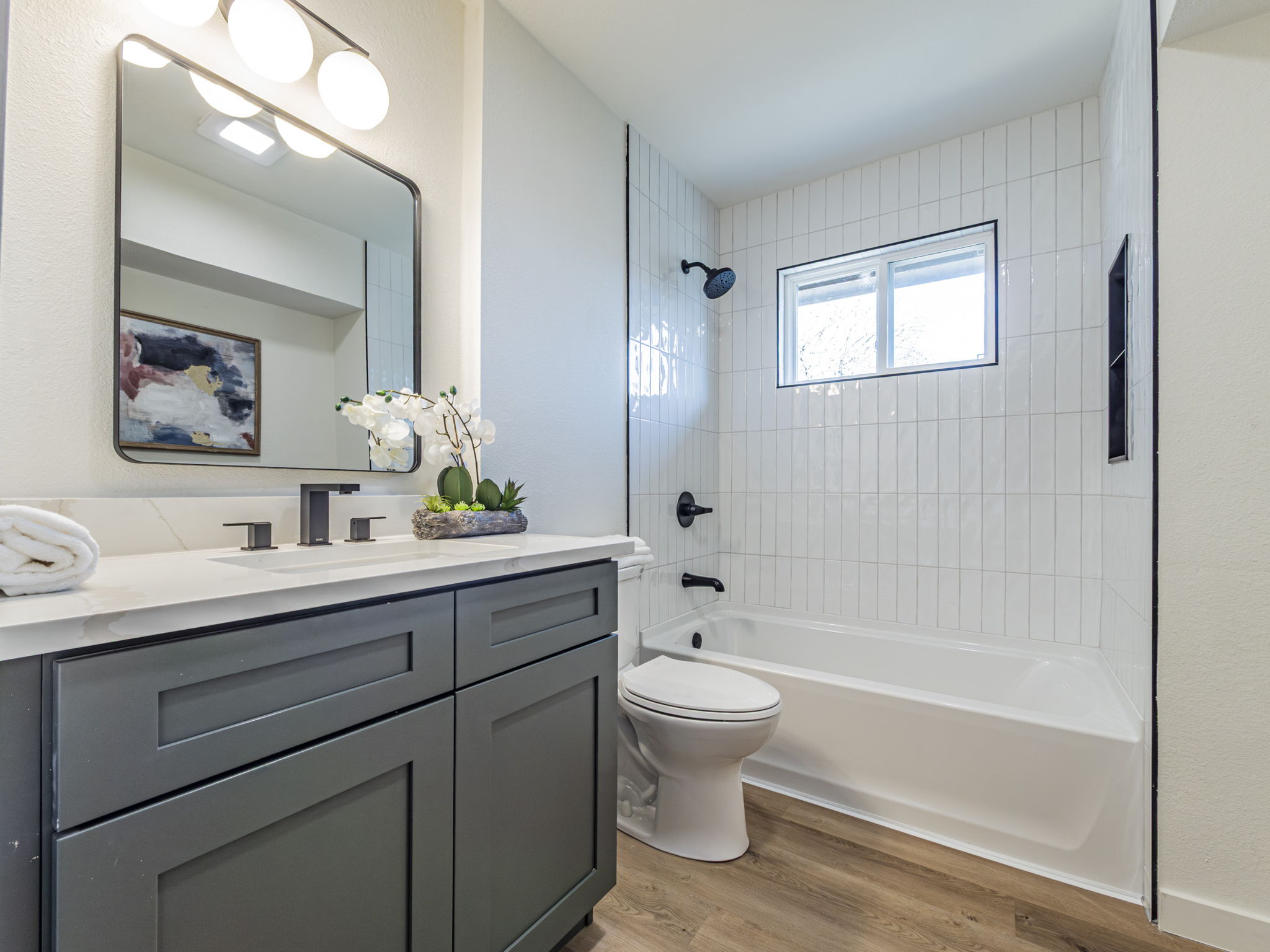 906 Fall Creek Drive Austin, TX 78753 - Photo 16 of 25 Bathroom featuring vanity, shower combination, and light wood finished floors