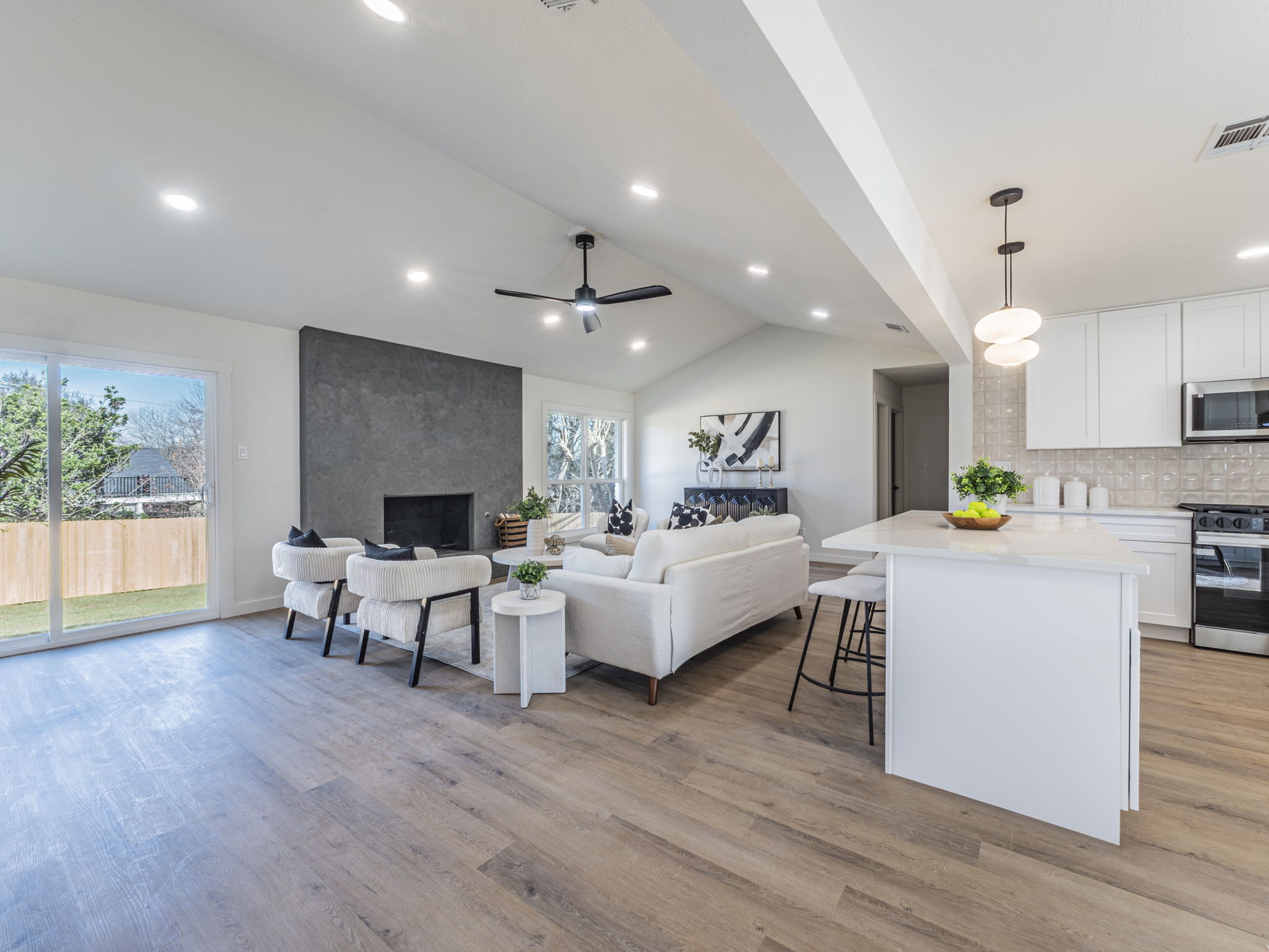 906 Fall Creek Drive Austin, TX 78753 - Photo 2 of 25 Living area featuring light wood-style floors, ceiling fan, vaulted ceiling, a large fireplace, and recessed lighting