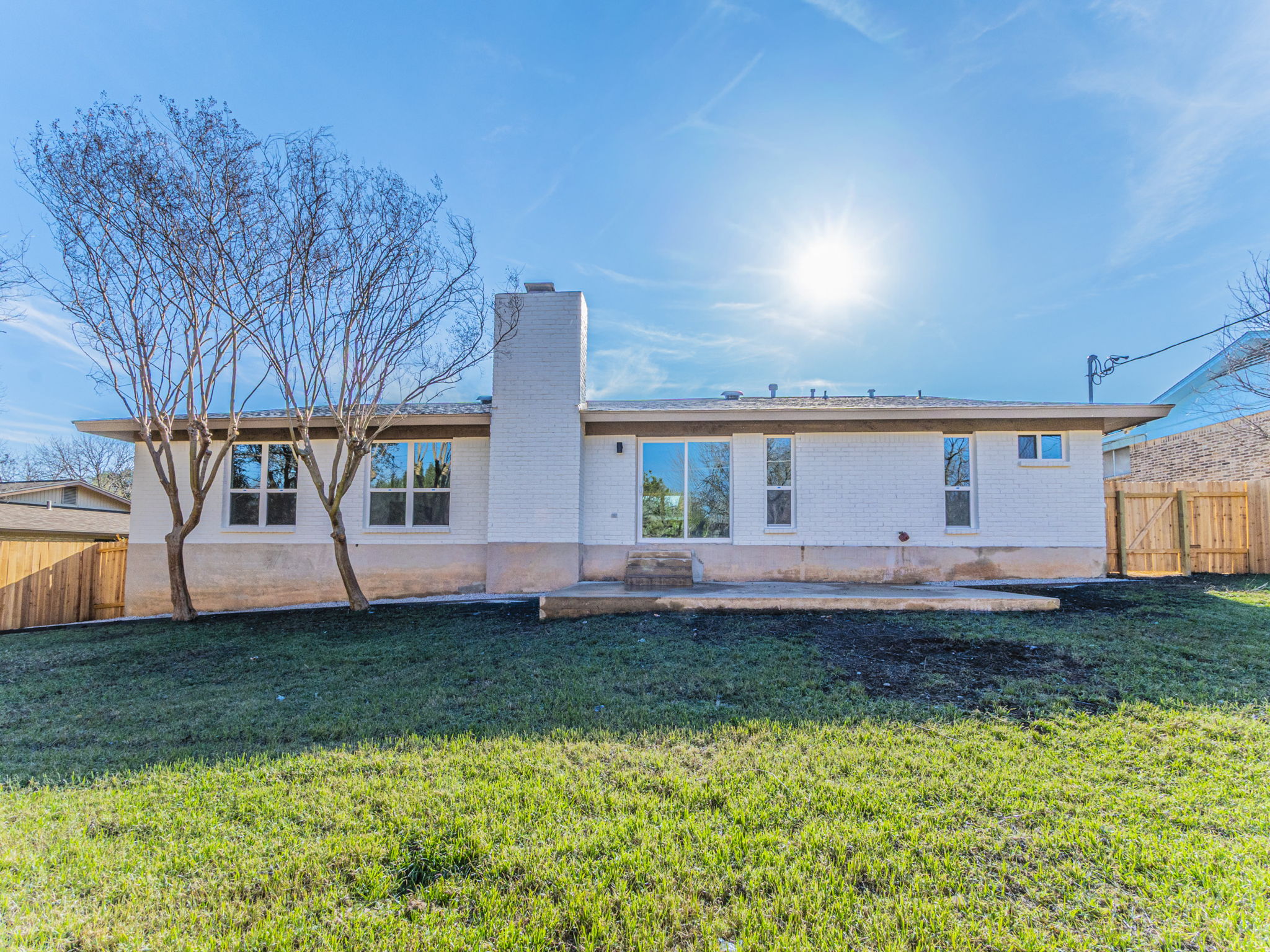 906 Fall Creek Drive Austin, TX 78753 - Photo 22 of 25 Back of property featuring a fenced backyard, a patio area, brick siding, a chimney, and a gate