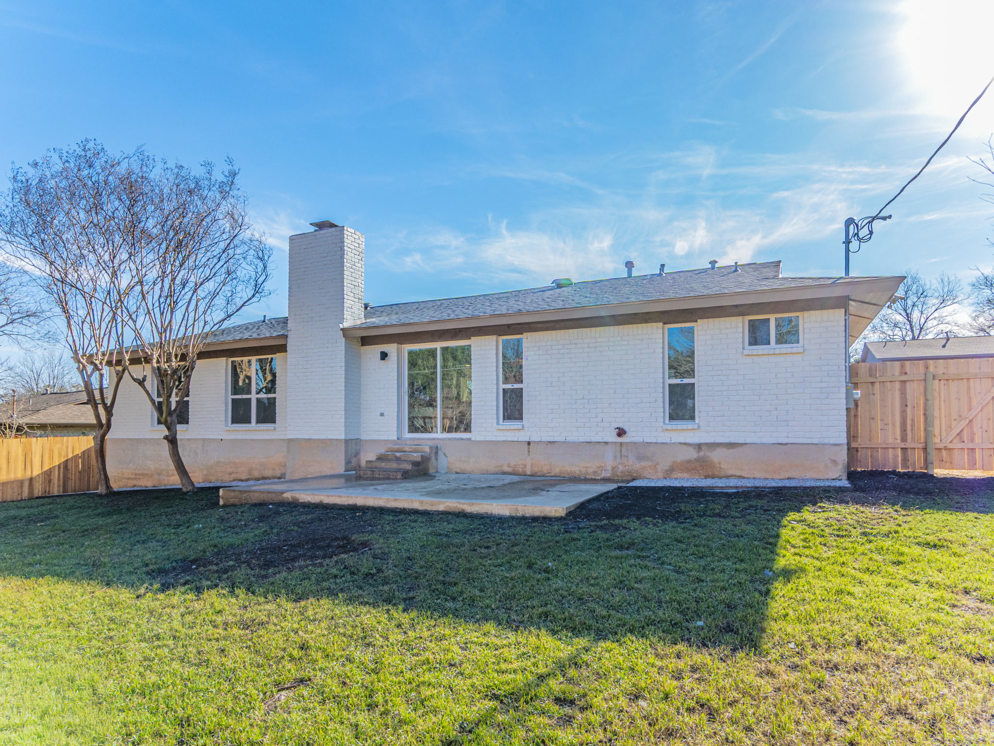 906 Fall Creek Drive Austin, TX 78753 - Photo 23 of 25 Back of property featuring a fenced backyard, a patio, brick siding, and a chimney
