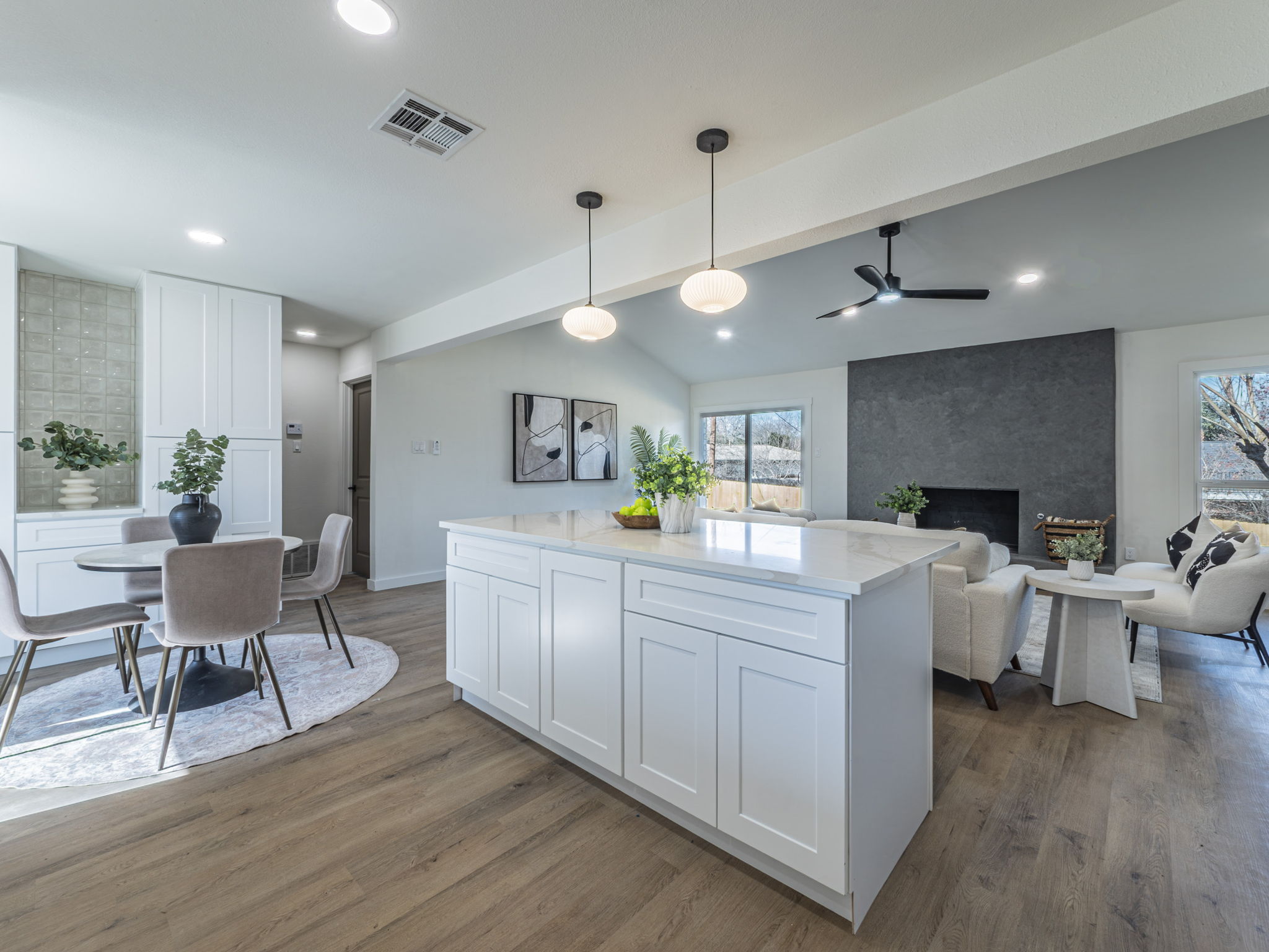 906 Fall Creek Drive Austin, TX 78753 - Photo 25 of 25 Kitchen with hanging light fixtures, white cabinets, light stone counters, open floor plan, and dark wood-style floors
