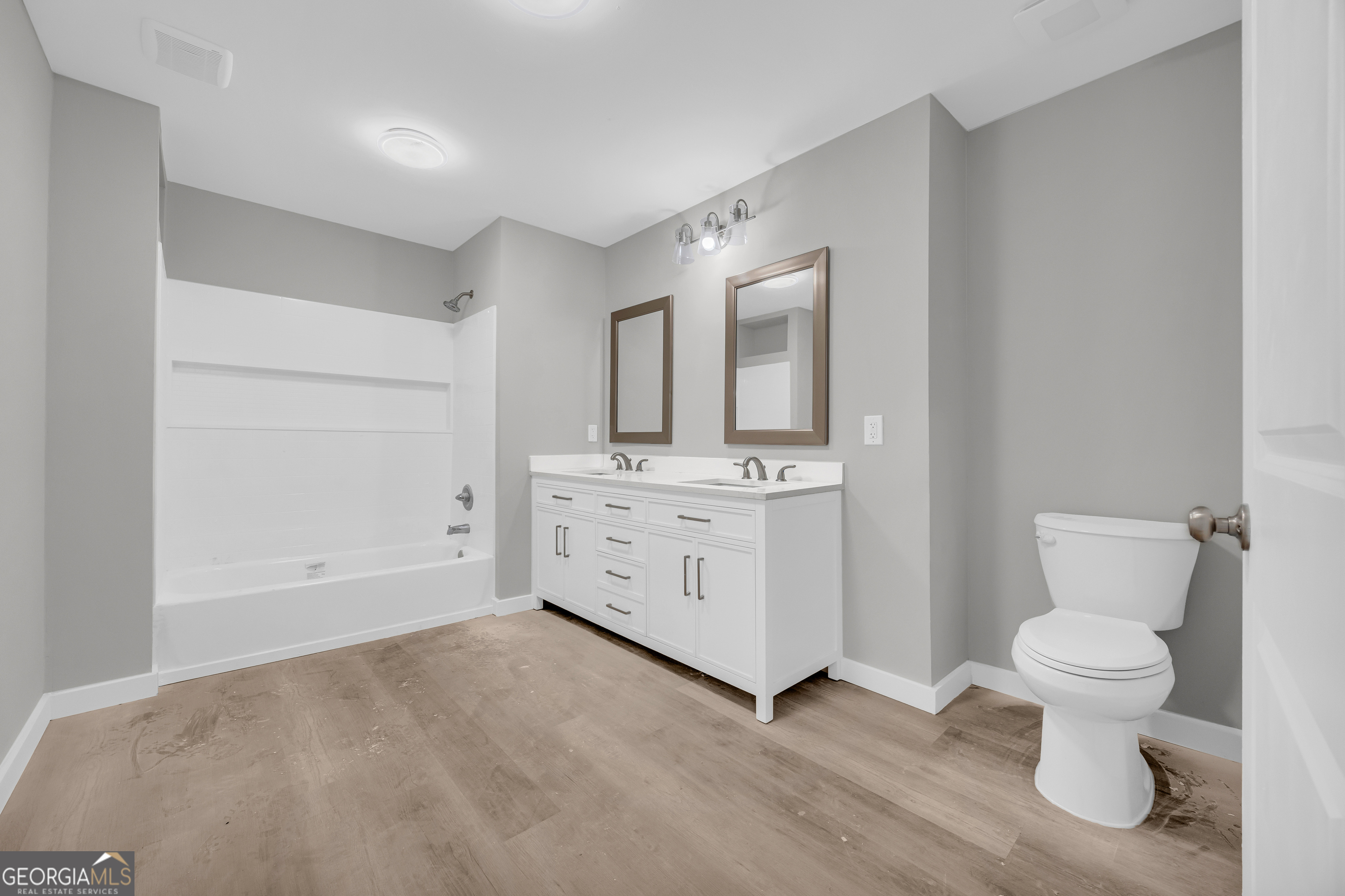 8606 Holly Springs Road Maysville, GA 30558 - Photo 62 of 74 a spacious bathroom with a toilet sink and mirror