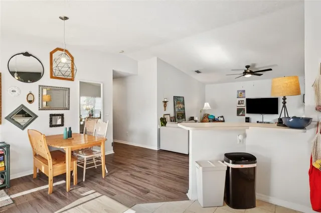 a kitchen with a dining table chairs and white cabinets