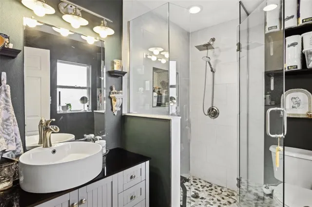 a bathroom with a sink a toilet and shower