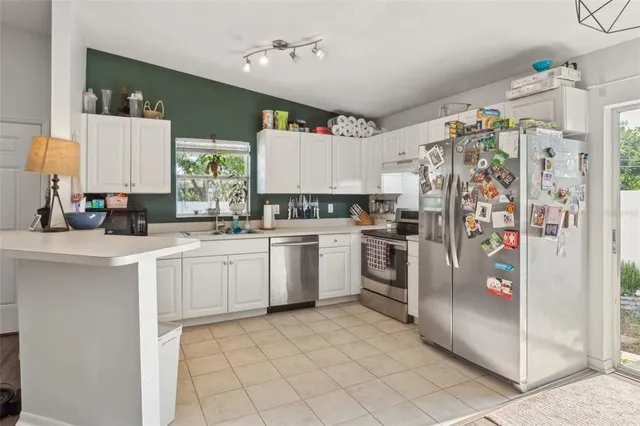a kitchen with white cabinets and white appliances