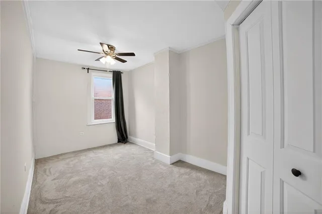 a view of an empty room with a chandelier fan