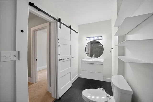 a bathroom with a toilet a sink and a mirror