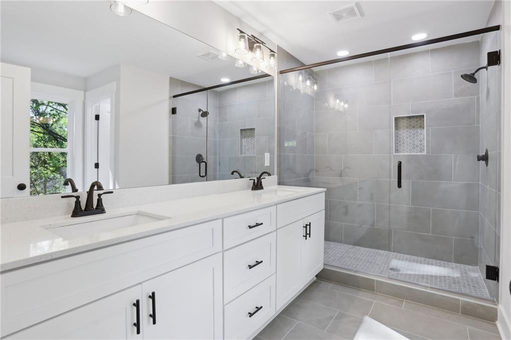 992 Coleman Street Southwest Atlanta, GA 30310 - Photo 15 of 18 a bathroom with a granite countertop sink a mirror a shower and a bathtub