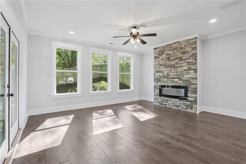 992 Coleman Street Southwest Atlanta, GA 30310 - Photo 6 of 18 a view of an empty room with wooden floor fireplace and a window