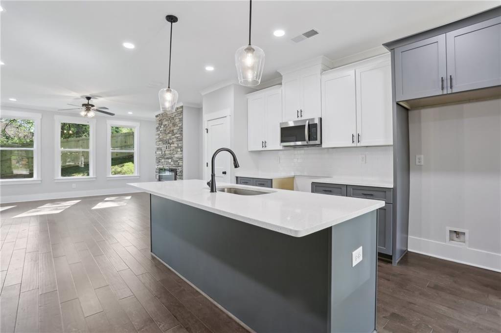 992 Coleman Street Southwest Atlanta, GA 30310 - Photo 9 of 18 a kitchen with a sink a center island a wooden floor and cabinets