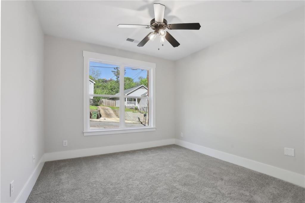 992 Coleman Street Southwest Atlanta, GA 30310 - Photo 10 of 18 an empty room with windows and ceiling fan