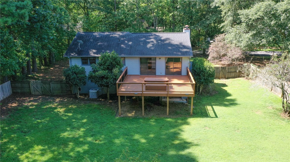 117 Shaftsbury Road Clemson, SC 29631 - Photo 28 of 29 An elevated wooden deck overlooks a grassy backyard bordered by mature trees.