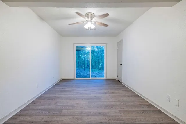 an empty room with fan and windows