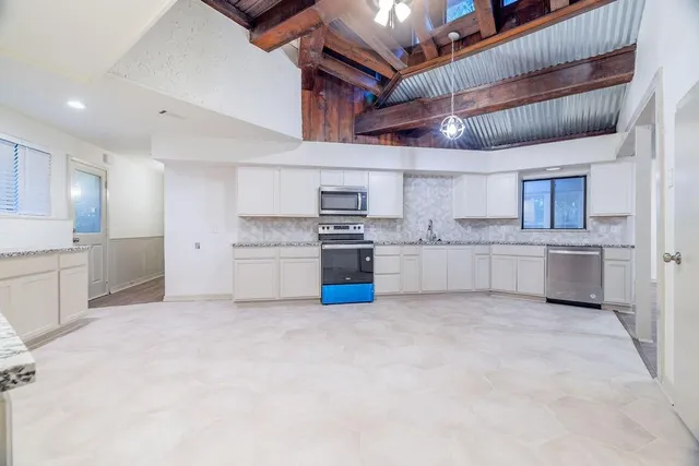 a kitchen with cabinets and stainless steel appliances