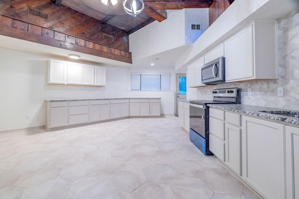 598 Stagecoach Trail Denison, TX 75021 - Photo 3 of 29 a large white kitchen with stainless steel appliances granite countertop a stove sink and cabinets