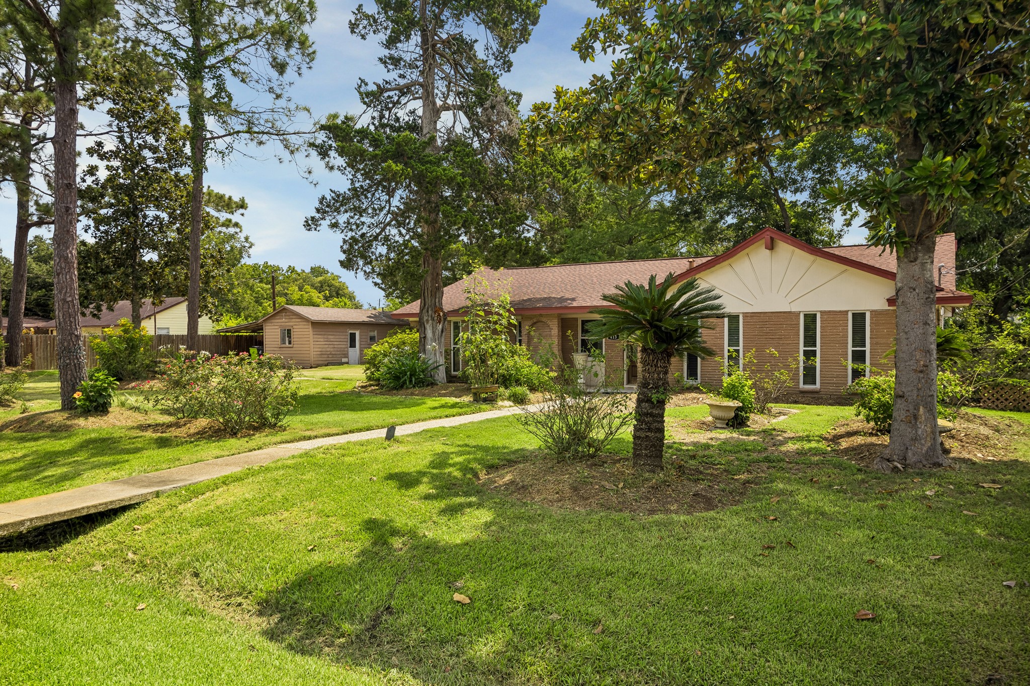 413 Mebane Lane Rosenberg, TX 77471 - Photo 8 of 30 This one story brick home is surrounded by lush greenery and mature trees, featuring a well-maintained lawn and a welcoming path leading to the entrance. The two homes and large lots make this ideal for those seeking a serene and private setting.
