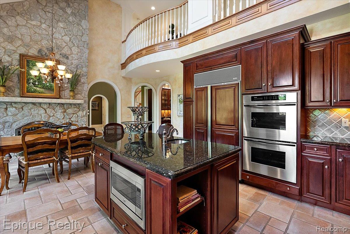 7662 Devins Ridge Clarkston, MI 48348 - Photo 36 of 81 Gourmet kitchen featuring rich wood cabinetry, granite countertops, and stainless steel double ovens