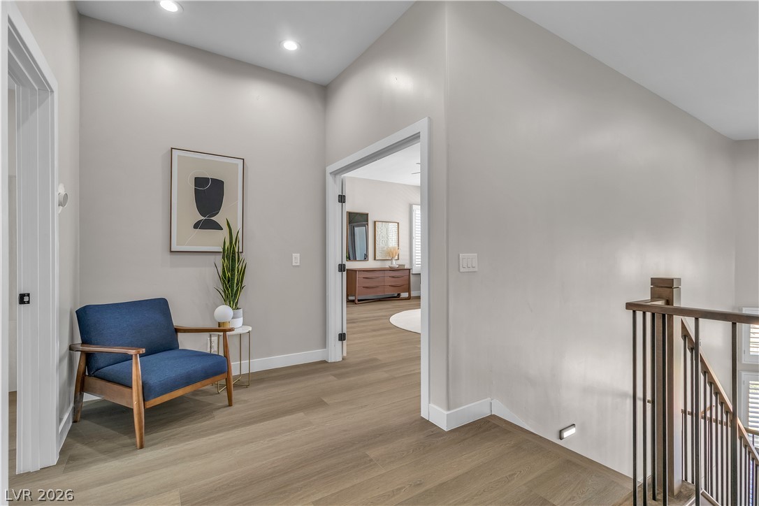 8848 Rainbow Ridge Drive Las Vegas, NV 89117 - Photo 25 of 43 A well-lit landing area features sleek wood flooring and a modern banister leading to the lower level.