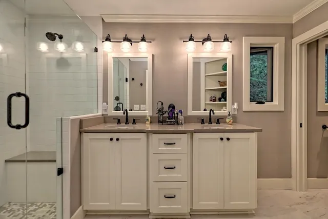 a bathroom with a double vanity sink and mirror with shower