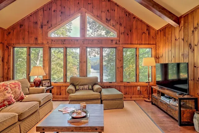 a living room with furniture a flat screen tv and a floor to ceiling window