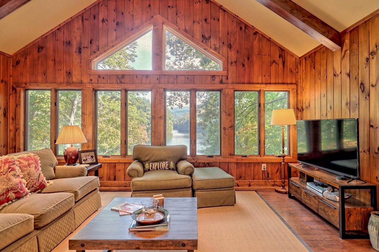 728 Oscar Rock Road Clayton, GA 30525 - Photo 9 of 40 a living room with furniture a flat screen tv and a floor to ceiling window