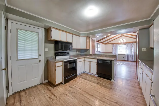 a kitchen with granite countertop a stove top oven and cabinets