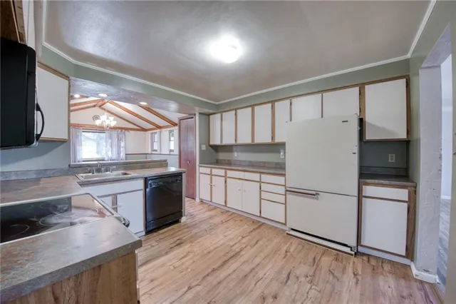 a kitchen with granite countertop a refrigerator stove top oven and sink