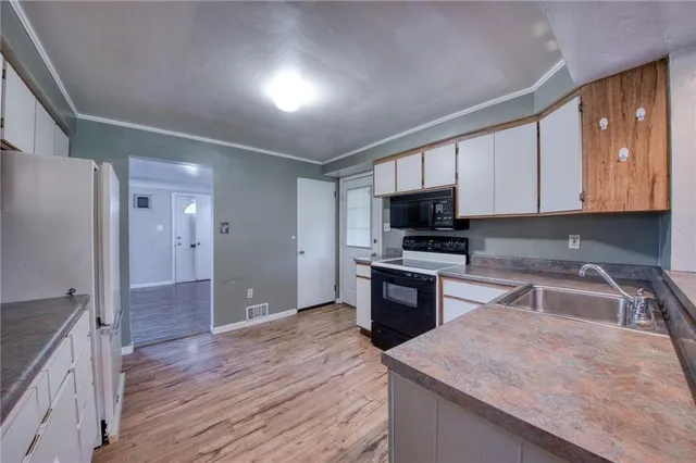 a kitchen with granite countertop wooden cabinets a stove oven and refrigerator