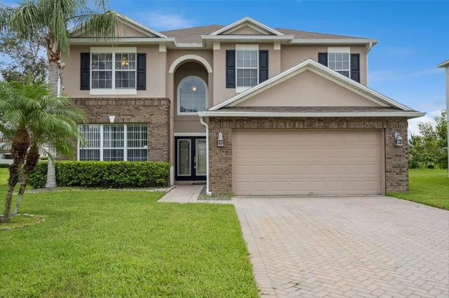 a front view of a house with a yard and garage