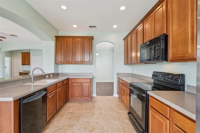 a kitchen with stainless steel appliances granite countertop a sink stove and cabinets
