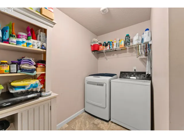 a utility room with lots of clutter and refrigerator