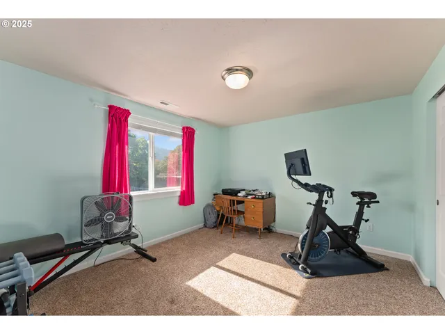 a living room with furniture gym equipment and a window