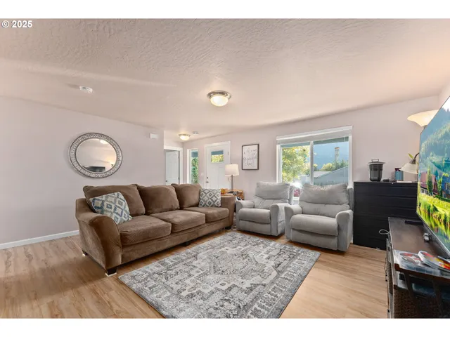 a living room with furniture and a wooden floor