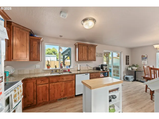 a kitchen with a sink a stove cabinets and living room