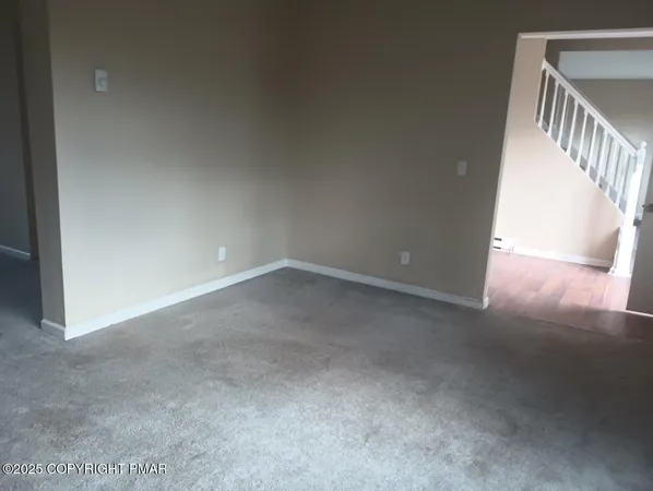 a view of an empty room with staircase