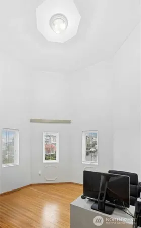 a view of workspace with wooden floor and a window