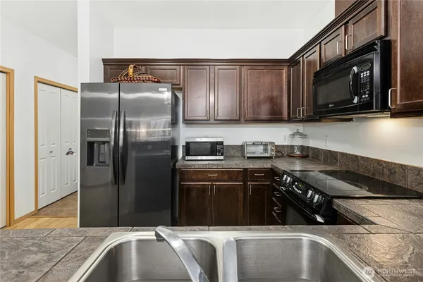 a kitchen with a sink and steel appliances