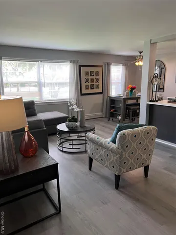 a living room with furniture fireplace and a large window