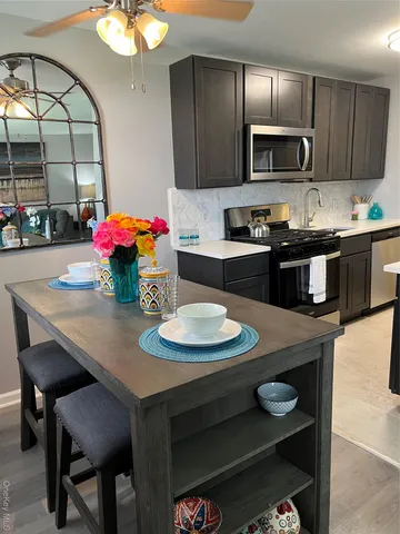 a kitchen with a sink a stove and chairs