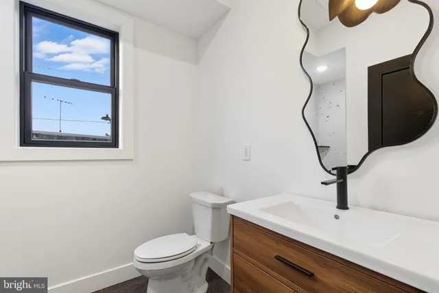 a bathroom with a sink a toilet and mirror